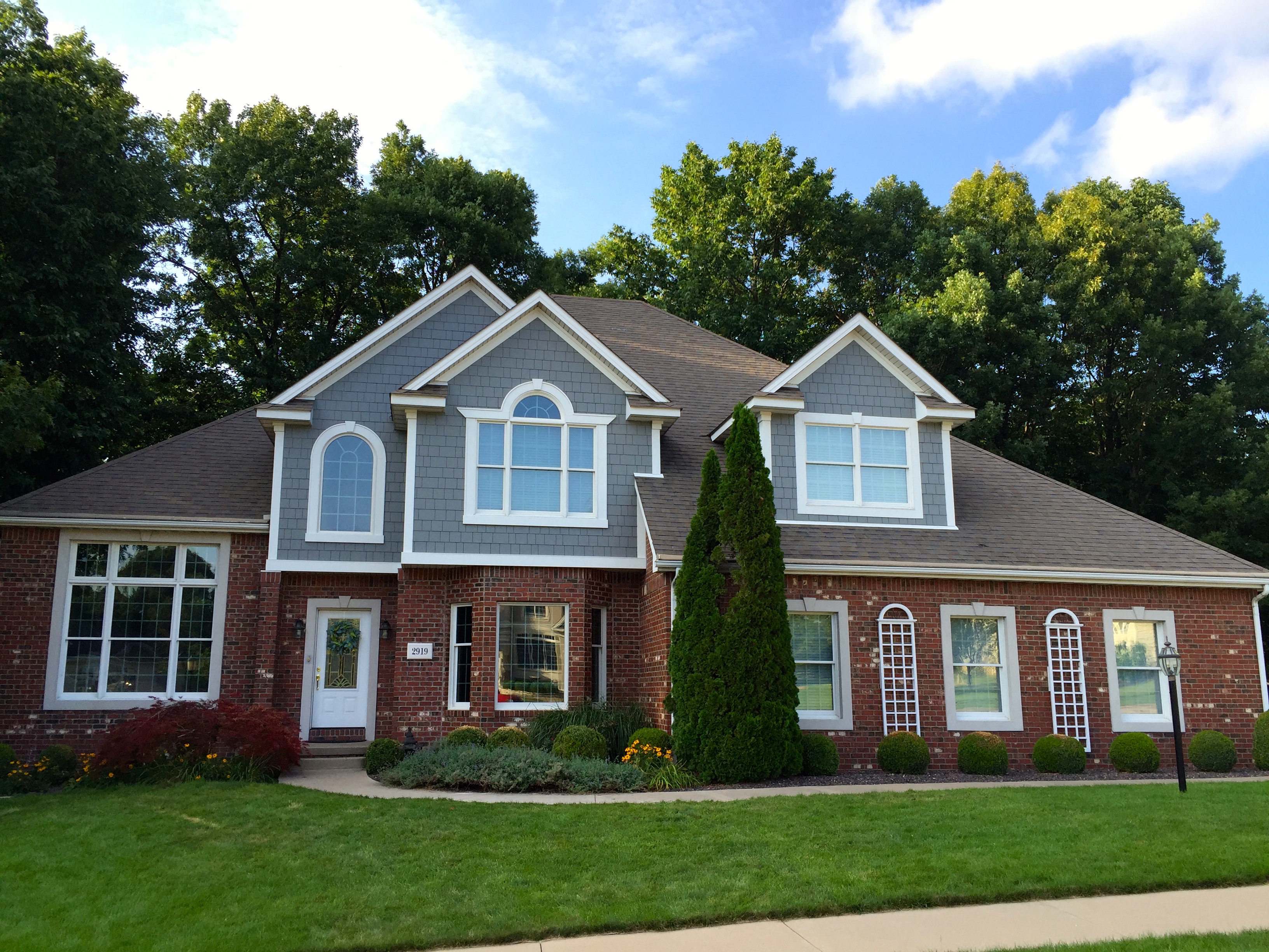 two story house with brick and fiber cement shake gables